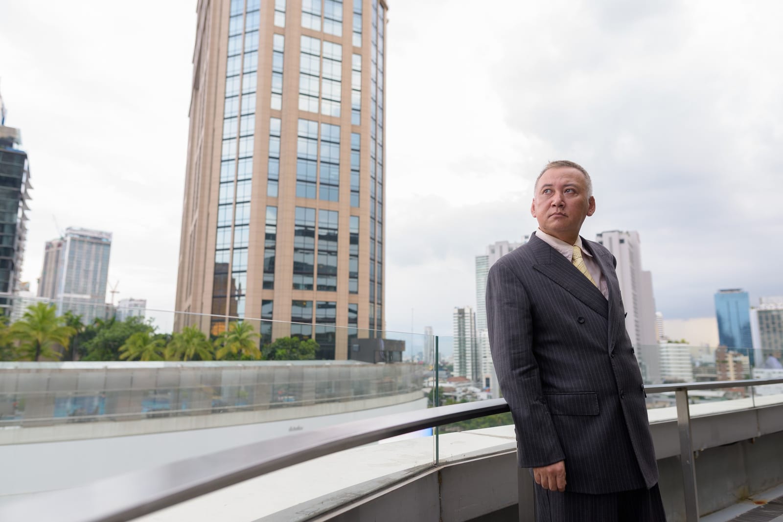 ガラステーブルでノートパソコンと印刷したグラフを見ながら家計を話し合う夫婦。